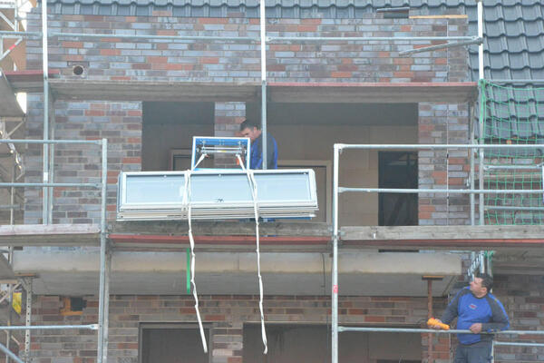 Het frame van de balkondeur wordt over de steiger getrokken